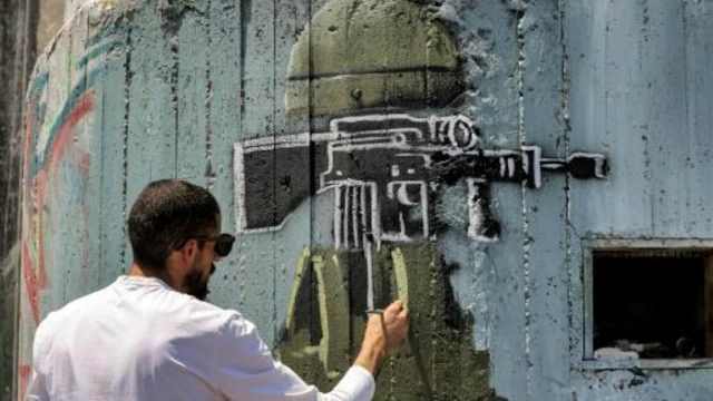 فرانس برس: فنان فلسطيني يندد بالاحتلال من خلال رسوم غرافيتي على «الجدار» الإسرائيلي